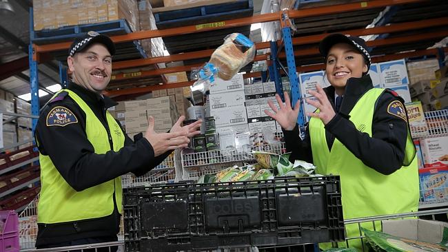 Trainee constables Nathan Wheldon and Nikayla Roach packing hampers at Foodbank for the festive season. Picture: Luke Bowden